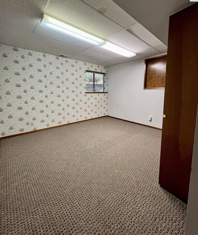 basement featuring carpet floors and a drop ceiling