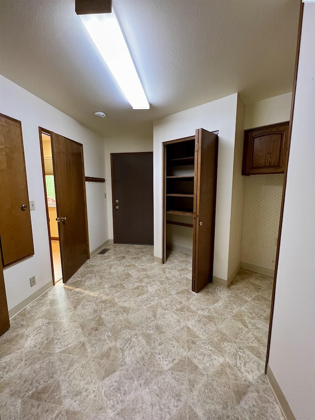 unfurnished bedroom with multiple closets and a textured ceiling