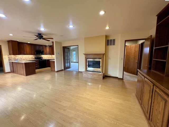 kitchen with tasteful backsplash, black / electric stove, ceiling fan, and light hardwood / wood-style flooring