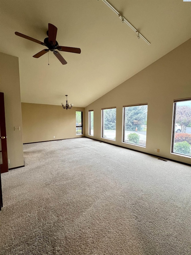 spare room featuring ceiling fan with notable chandelier, carpet floors, track lighting, and high vaulted ceiling