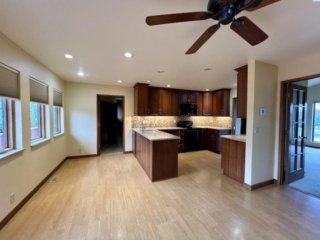 kitchen featuring sink, backsplash, black appliances, and kitchen peninsula