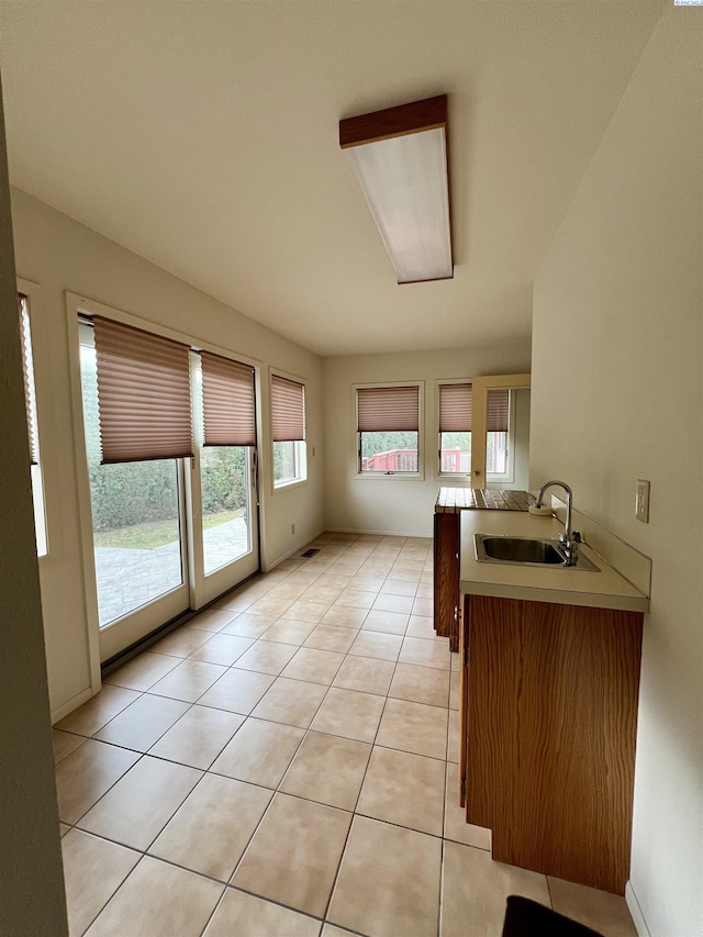 kitchen featuring sink, light tile patterned floors, and kitchen peninsula