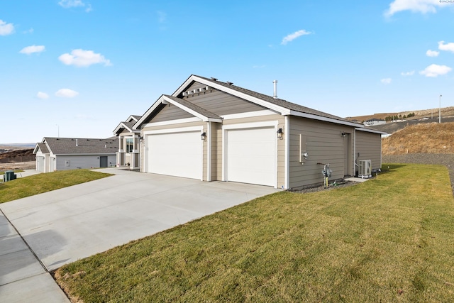 view of side of home with a yard, central AC unit, an attached garage, and driveway