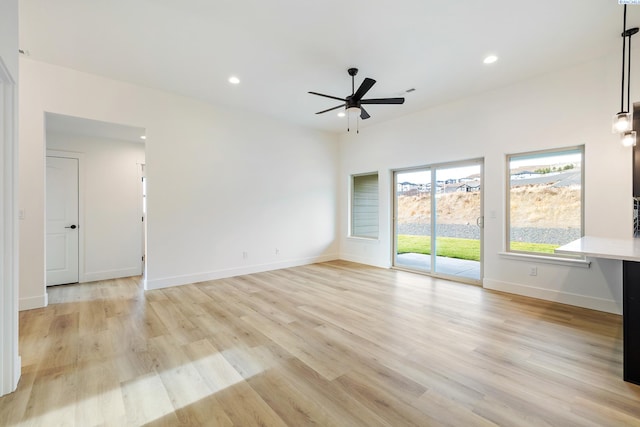 unfurnished living room featuring baseboards, recessed lighting, and light wood-style floors