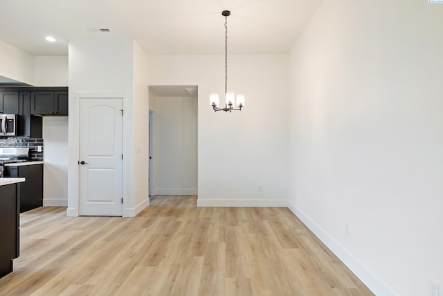 unfurnished dining area with light wood-style floors, a chandelier, visible vents, and baseboards