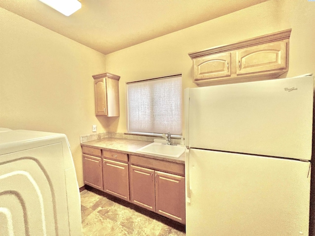 washroom with sink, washer / dryer, and cabinets