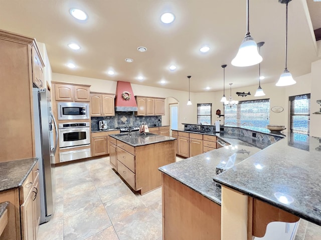 kitchen featuring a large island, hanging light fixtures, stainless steel appliances, and kitchen peninsula