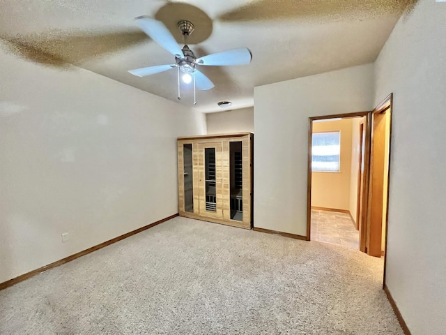 spare room featuring light colored carpet, a textured ceiling, and ceiling fan