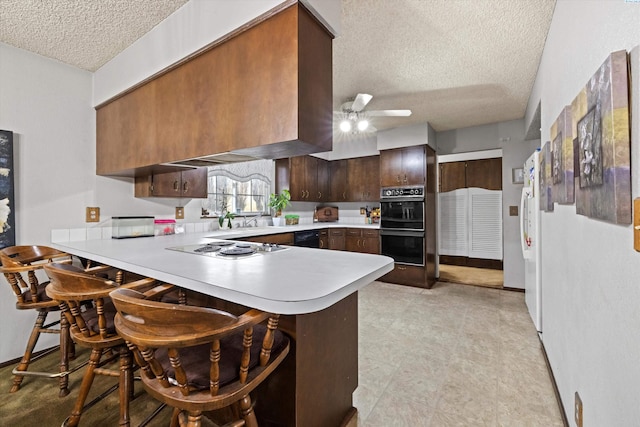 697 Conrad Rd, Touchet, WA 99360 - kitchen featuring a textured ceiling, light countertops, a peninsula, black appliances, and ceiling fan