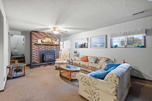 697 Conrad Rd, Touchet, WA 99360 - living room with a wood stove, a ceiling fan, a textured ceiling, and carpet floors