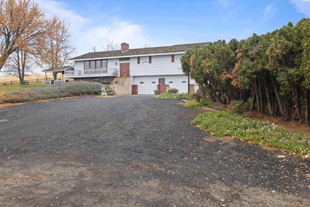 697 Conrad Rd, Touchet, WA 99360 - raised ranch featuring a garage, a chimney, brick siding, and driveway