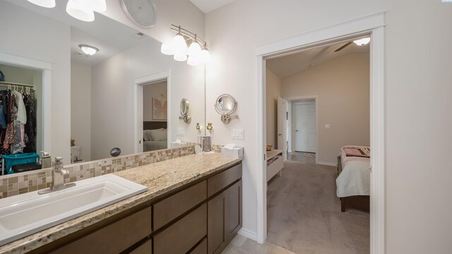 8902 Sophie Rae Ct, Pasco, WA 99301 - bathroom featuring connected bathroom, vanity, decorative backsplash, vaulted ceiling, and a spacious closet