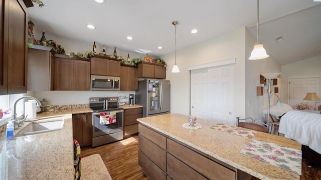 8902 Sophie Rae Ct, Pasco, WA 99301 - kitchen with stainless steel appliances, wood finished floors, decorative light fixtures, light stone countertops, and recessed lighting