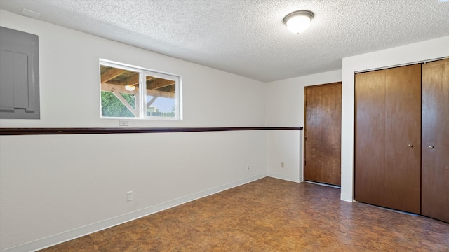 1707 S Fruitland St, Kennewick, WA 99337 - unfurnished bedroom with tile patterned floors, multiple closets, and a textured ceiling