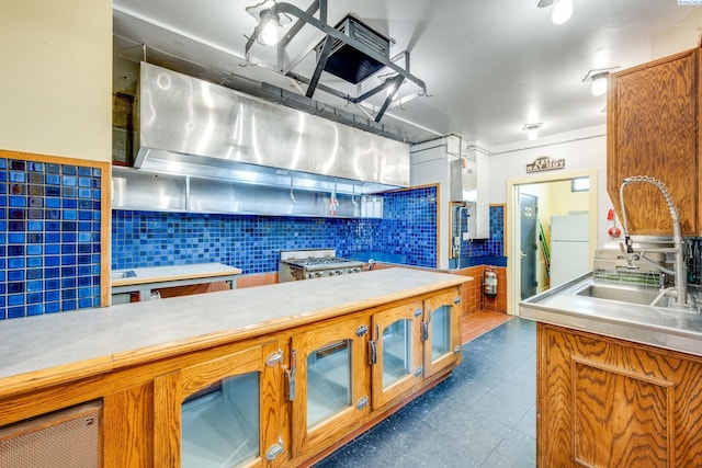 kitchen with range, sink, white fridge, and backsplash