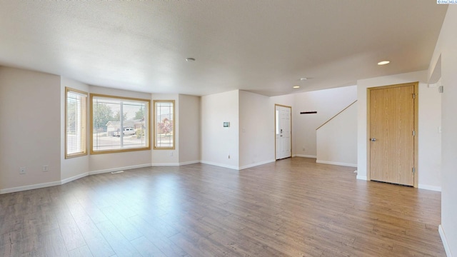 4613 Atlanta Ln, Pasco, WA 99301 - unfurnished living room featuring light wood-style floors, baseboards, recessed lighting, and stairway