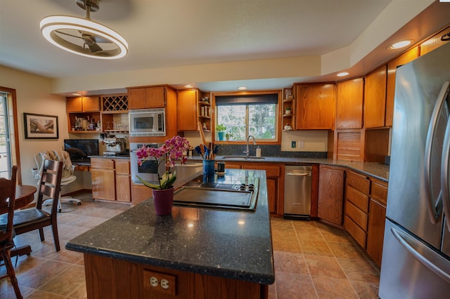 2929 S Ledbetter Pl, Kennewick, WA 99337 - kitchen with appliances with stainless steel finishes, open shelves, a center island, brown cabinetry, and a desk