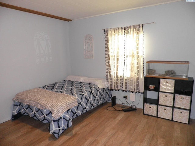 bedroom featuring crown molding and hardwood / wood-style flooring