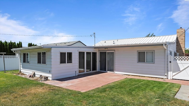 2111 W 20th Ave, Kennewick, WA 99337 - rear view of house with a patio area, a gate, a chimney, and a metal roof