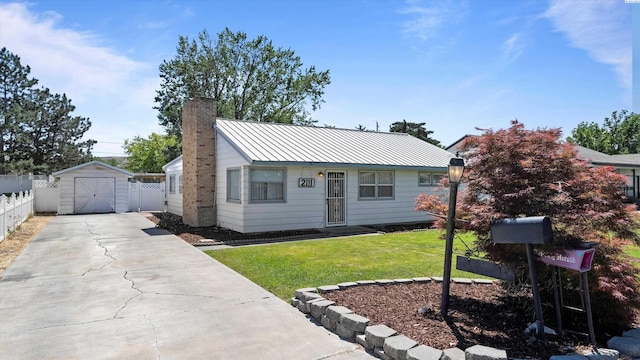 2111 W 20th Ave, Kennewick, WA 99337 - view of front facade with a chimney, driveway, a storage unit, a detached garage, and a metal roof