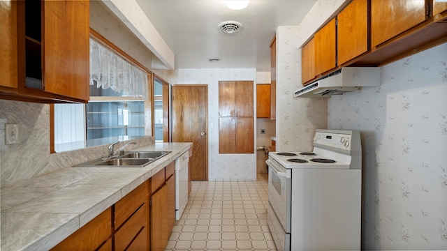 2111 W 20th Ave, Kennewick, WA 99337 - kitchen featuring white appliances, under cabinet range hood, brown cabinets, wallpapered walls, and light flooring