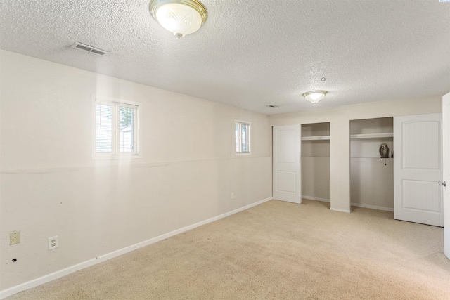 1621 S Fruitland St, Kennewick, WA 99337 - unfurnished bedroom with multiple closets, carpet floors, a textured ceiling, and multiple windows