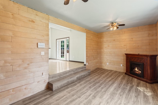 1621 S Fruitland St, Kennewick, WA 99337 - unfurnished living room with a ceiling fan, wood walls, light wood finished floors, and a glass covered fireplace