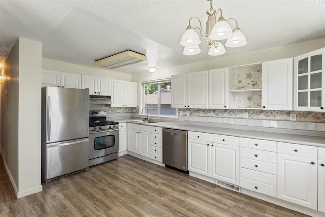 1621 S Fruitland St, Kennewick, WA 99337 - kitchen featuring stainless steel appliances, a chandelier, white cabinets, wood finished floors, and a textured ceiling
