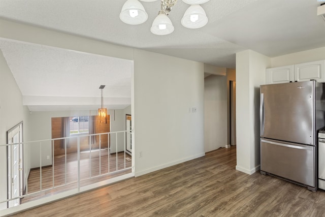 1621 S Fruitland St, Kennewick, WA 99337 - kitchen featuring freestanding refrigerator, a chandelier, wood finished floors, white cabinetry, and a textured ceiling