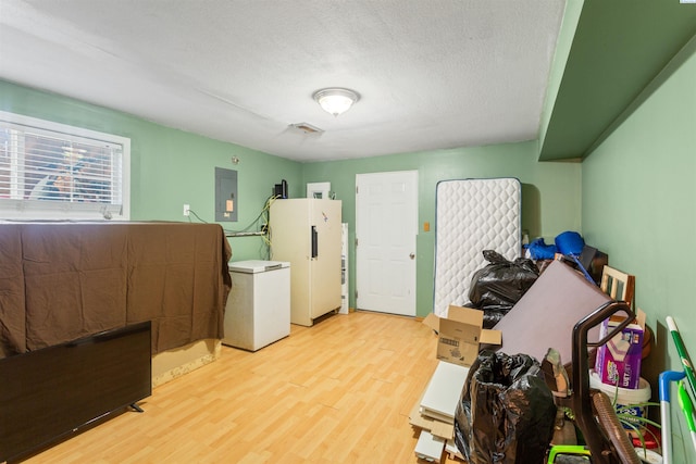1621 S Fruitland St, Kennewick, WA 99337 - misc room with light wood finished floors, electric panel, and a textured ceiling
