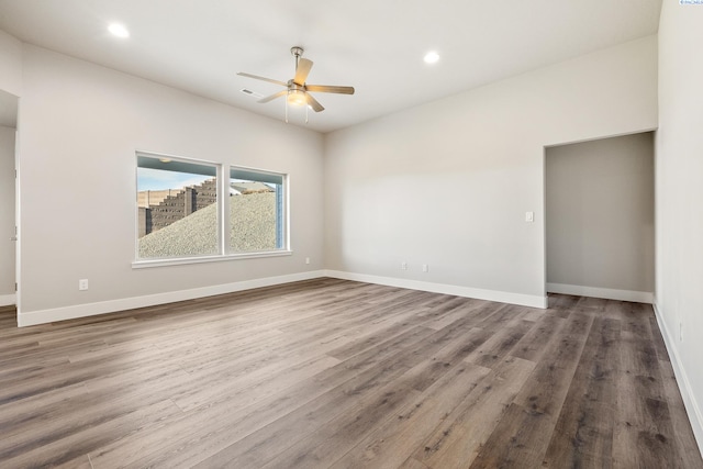 spare room featuring a ceiling fan, baseboards, wood finished floors, and recessed lighting