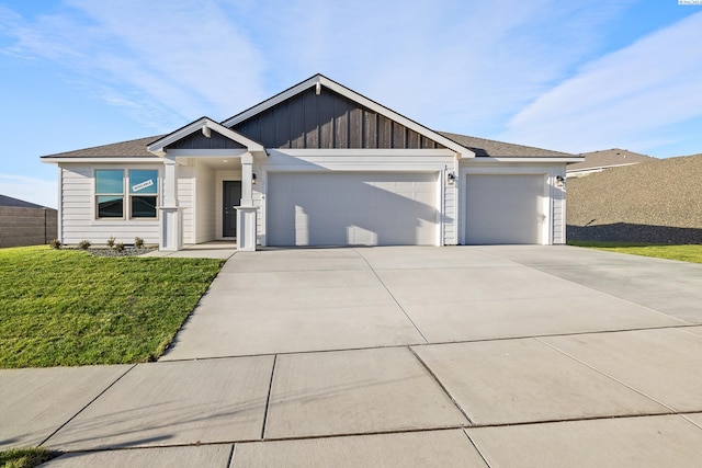 view of front of house with a garage, board and batten siding, concrete driveway, and a front yard