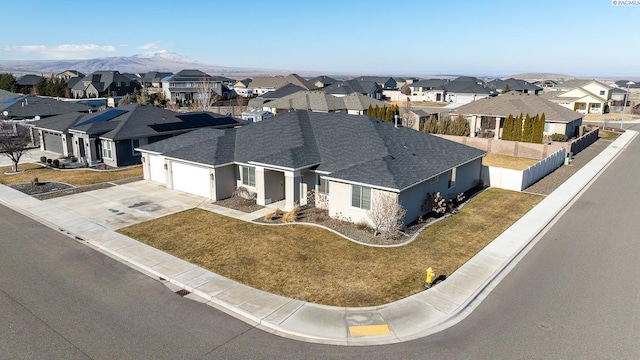 view of front of house with a mountain view, fence, a residential view, and a garage