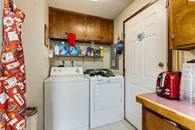 5820 W Park Pl, Pasco, WA 99301 - washroom with washer and clothes dryer, cabinet space, light tile patterned flooring, a textured ceiling, and electric panel
