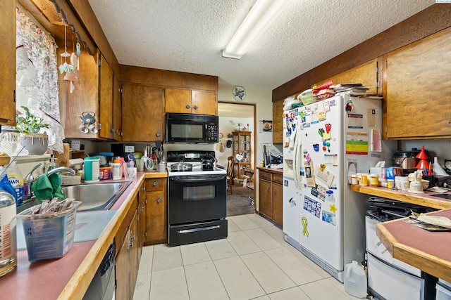 5820 W Park Pl, Pasco, WA 99301 - kitchen with black appliances, brown cabinets, light countertops, a textured ceiling, and light tile patterned flooring