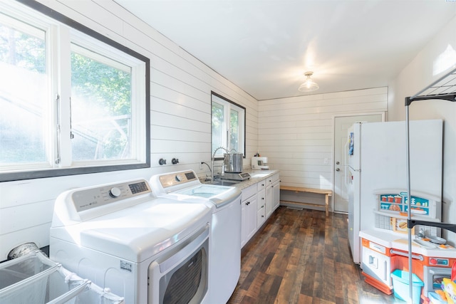 625 SW Dawnview Ct, Pullman, WA 99163 - washroom featuring washer and clothes dryer, cabinet space, dark wood-type flooring, and wooden walls