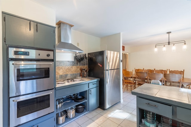 625 SW Dawnview Ct, Pullman, WA 99163 - kitchen featuring wall chimney exhaust hood, appliances with stainless steel finishes, decorative backsplash, light tile patterned floors, and open shelves