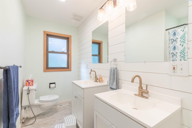 625 SW Dawnview Ct, Pullman, WA 99163 - bathroom featuring wood finished floors, toilet, two vanities, and baseboards