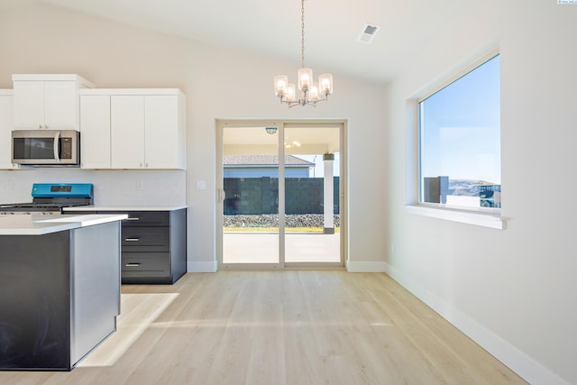 6435 W 30th Pl, Kennewick, WA 99338 - kitchen featuring stainless steel microwave, gas stove, lofted ceiling, light wood finished floors, and a chandelier