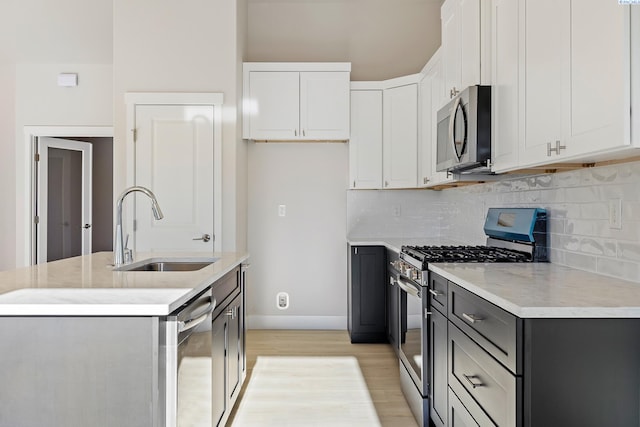 6435 W 30th Pl, Kennewick, WA 99338 - kitchen featuring stainless steel appliances, light wood-style flooring, decorative backsplash, and a kitchen island with sink