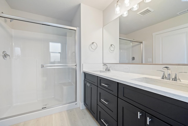 6435 W 30th Pl, Kennewick, WA 99338 - bathroom featuring a stall shower, double vanity, and wood finished floors