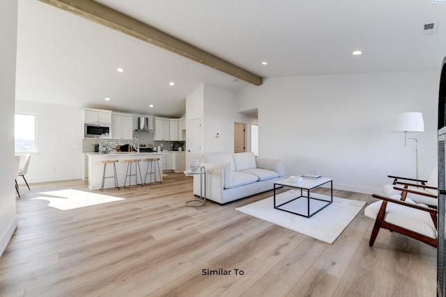 living area featuring light wood finished floors, baseboards, and recessed lighting