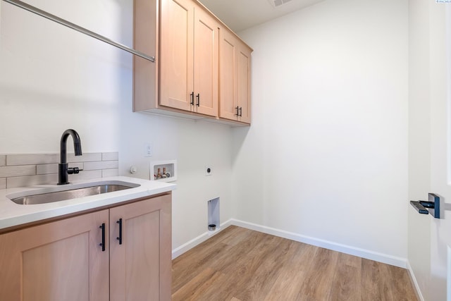 laundry room featuring sink, cabinets, hookup for a washing machine, electric dryer hookup, and light hardwood / wood-style flooring