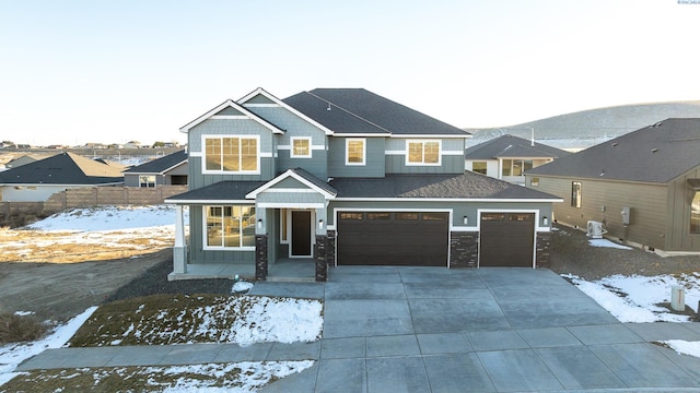 view of front of house with board and batten siding, driveway, a shingled roof, and fence