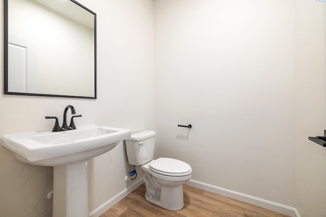 bathroom with wood-type flooring and toilet