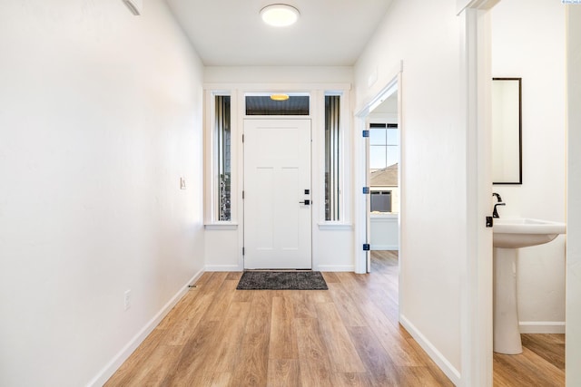 doorway featuring sink and light wood-type flooring