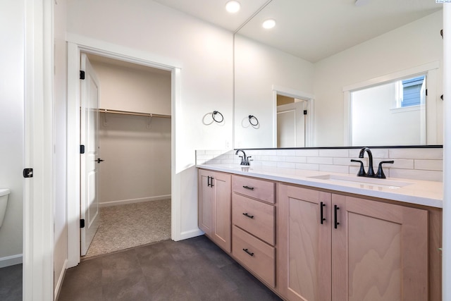 bathroom with vanity, backsplash, and toilet