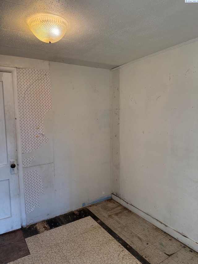 unfurnished room with a textured ceiling