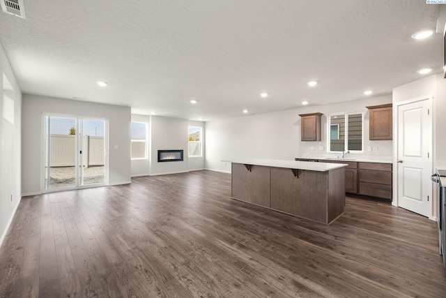 704 S Zeelar St, Kennewick, WA 99336 - kitchen featuring a kitchen island, dark wood-type flooring, a textured ceiling, light countertops, and open floor plan