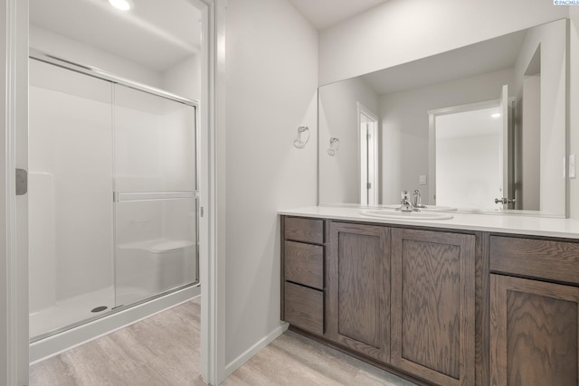 704 S Zeelar St, Kennewick, WA 99336 - full bath featuring wood finished floors, vanity, a shower stall, and baseboards